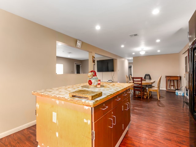 kitchen with a kitchen island and dark hardwood / wood-style flooring