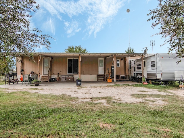 rear view of property featuring a lawn and a patio area