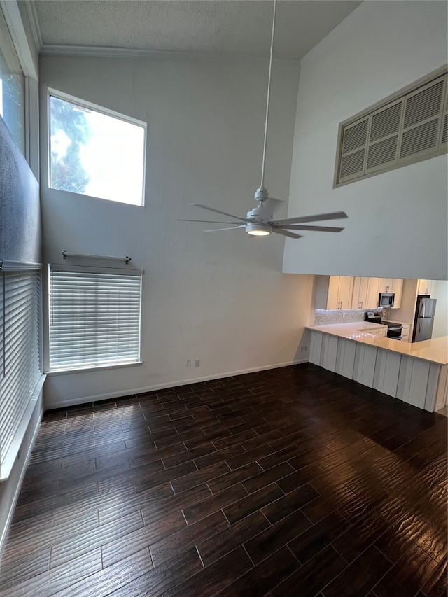 unfurnished living room with high vaulted ceiling, ceiling fan, dark wood-type flooring, and a textured ceiling