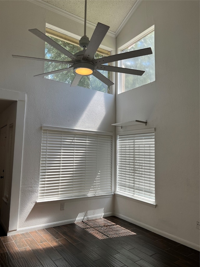 unfurnished room featuring ceiling fan, a textured ceiling, dark wood-type flooring, crown molding, and vaulted ceiling