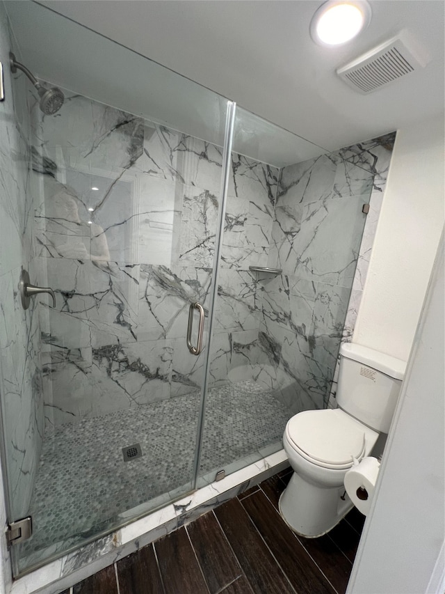 bathroom featuring walk in shower and toilet