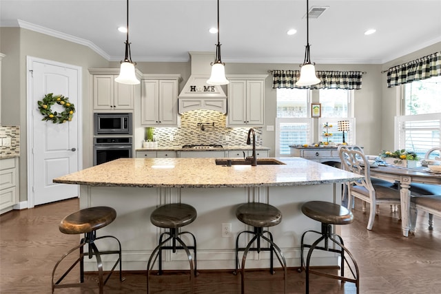 kitchen with a kitchen bar, light stone countertops, sink, and appliances with stainless steel finishes