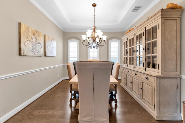 dining space with a tray ceiling, crown molding, a chandelier, and dark hardwood / wood-style floors