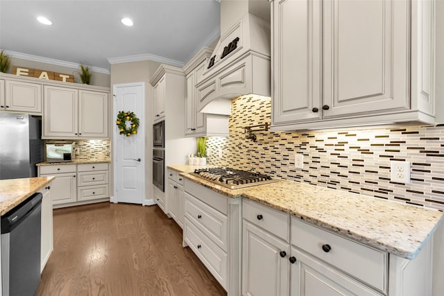 kitchen featuring appliances with stainless steel finishes, tasteful backsplash, dark wood-type flooring, crown molding, and white cabinetry