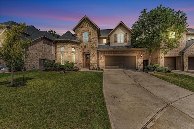 view of front of property with a garage and a yard