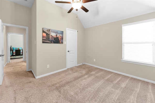 unfurnished room with light colored carpet, a wealth of natural light, and ceiling fan