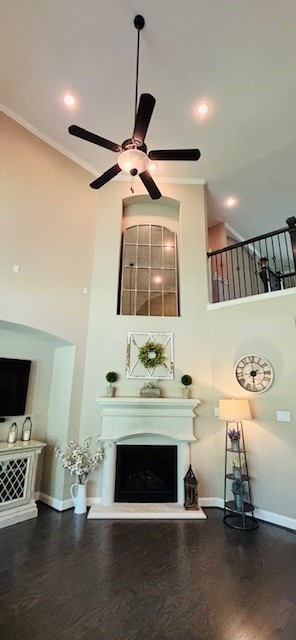 living room with ceiling fan, wood-type flooring, and ornamental molding