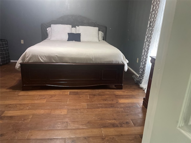 bedroom with dark wood-type flooring