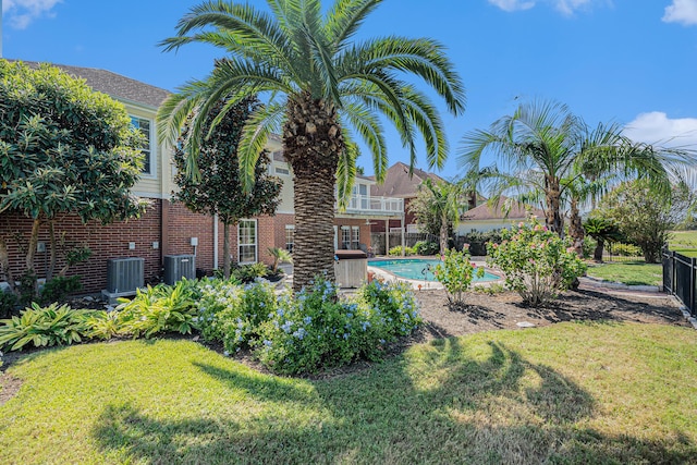 view of yard featuring central AC unit and a fenced in pool