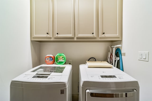 laundry area with cabinets and washing machine and dryer