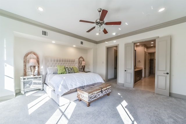 bedroom featuring light carpet, ensuite bathroom, ceiling fan, and ornamental molding