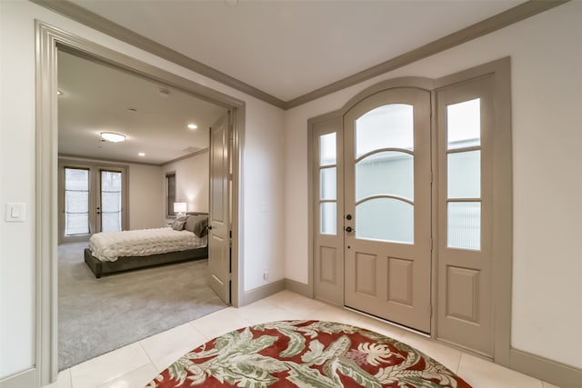 tiled entrance foyer featuring crown molding