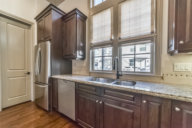 kitchen featuring sink, dark hardwood / wood-style floors, dishwashing machine, dark brown cabinets, and stainless steel refrigerator