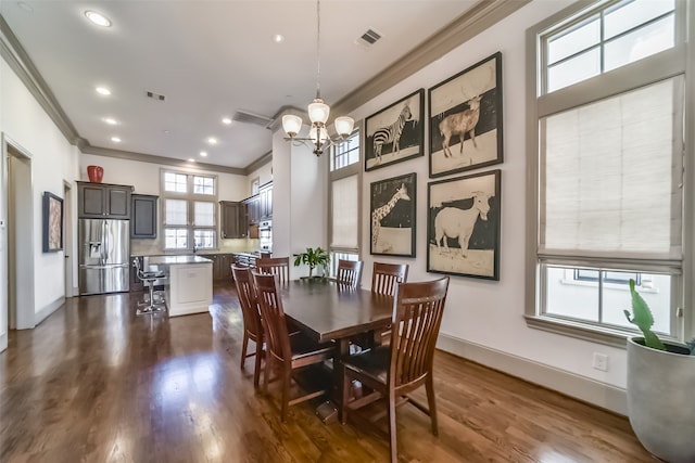 dining area featuring dark hardwood / wood-style flooring, a chandelier, and ornamental molding