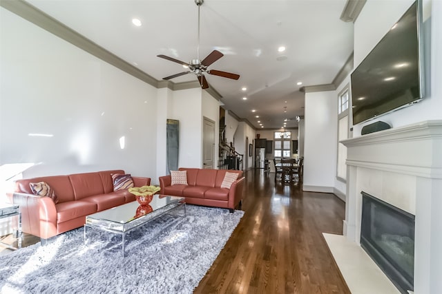 living room with dark hardwood / wood-style floors, ceiling fan, and crown molding