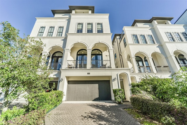 view of property with a balcony and a garage