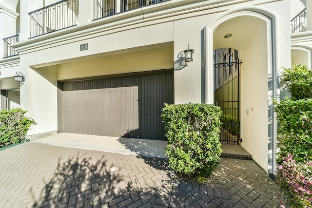 entrance to property featuring a balcony and a garage