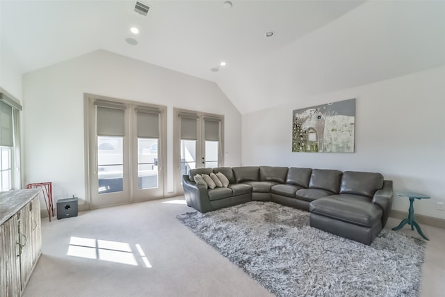 carpeted living room featuring french doors and vaulted ceiling