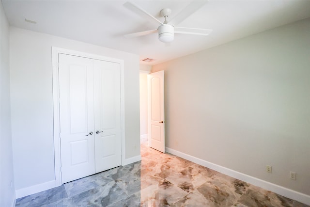 unfurnished bedroom with ceiling fan and a closet