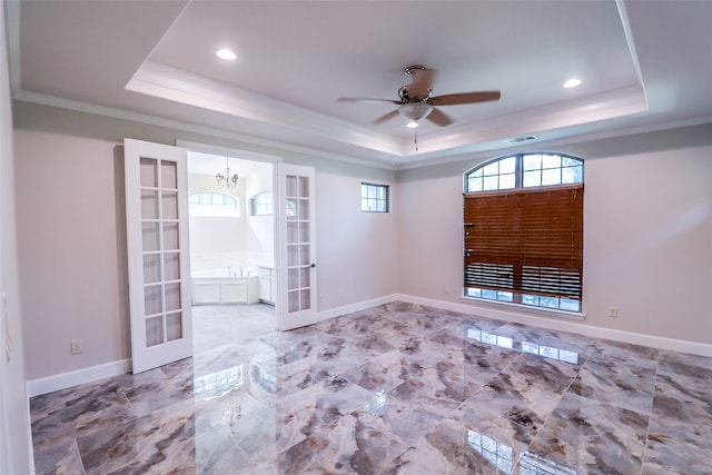 unfurnished room with ceiling fan with notable chandelier, crown molding, french doors, and a raised ceiling