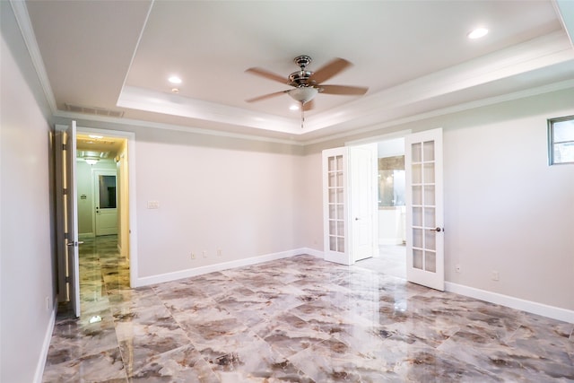 empty room with ornamental molding, ceiling fan, a raised ceiling, and french doors