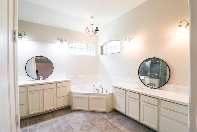 bathroom featuring a notable chandelier, vanity, and a bathing tub