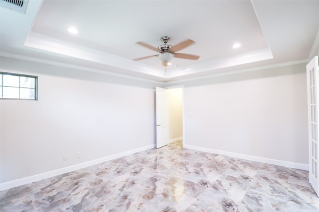 empty room with a tray ceiling, ceiling fan, and crown molding