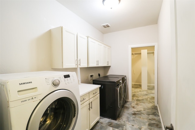 laundry area featuring cabinets and washer and clothes dryer