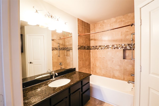 bathroom featuring tiled shower / bath, vanity, and tile patterned flooring