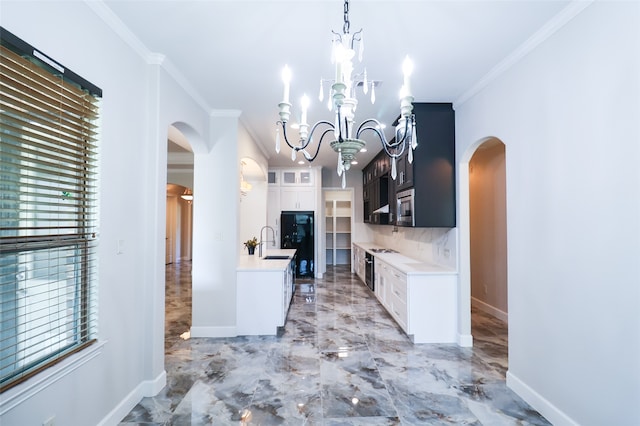 kitchen featuring a notable chandelier, white cabinets, sink, and ornamental molding