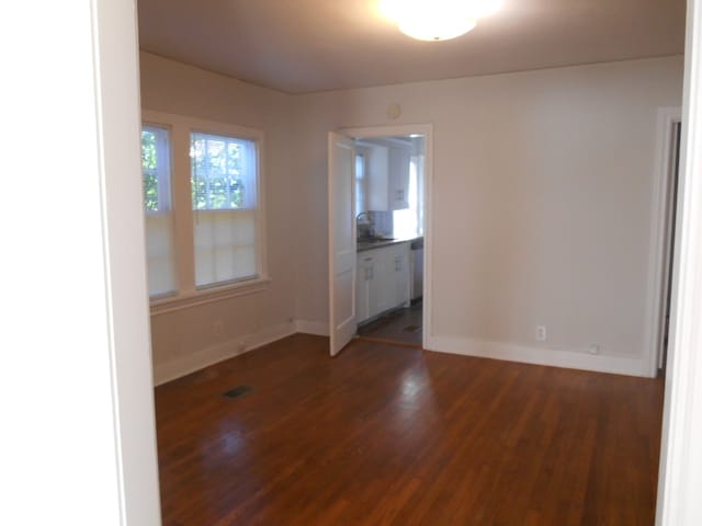 unfurnished room featuring sink and dark hardwood / wood-style flooring