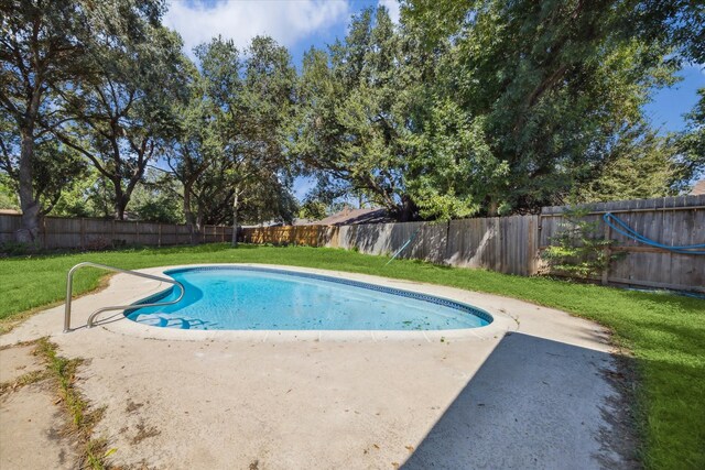 view of swimming pool featuring a patio and a yard