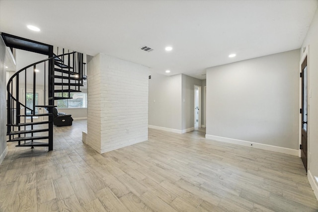 16007 Soma Dr, Houston, TX 77083 - unfurnished living room featuring baseboards, visible vents, light wood-type flooring, and stairs