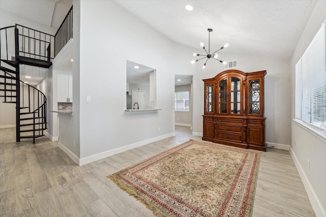 16007 Soma Dr, Houston, TX 77083 - foyer with wood finished floors, stairway, baseboards, visible vents, and a notable chandelier