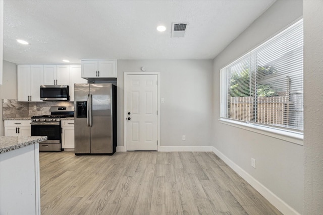 16007 Soma Dr, Houston, TX 77083 - kitchen with appliances with stainless steel finishes, light wood-style floors, baseboards, and backsplash