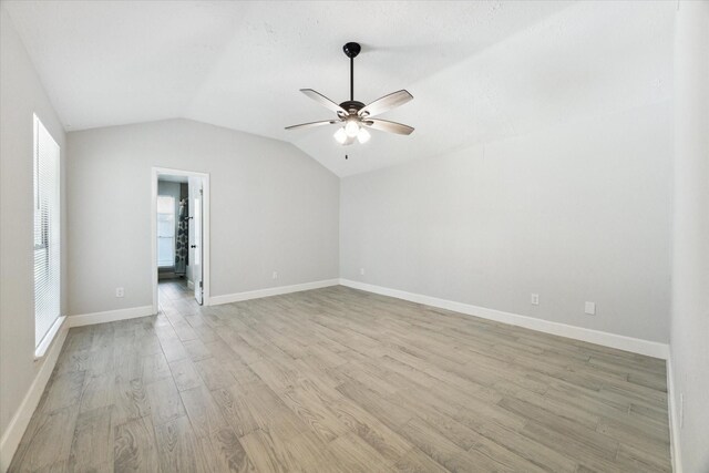 spare room featuring lofted ceiling, light hardwood / wood-style floors, and ceiling fan