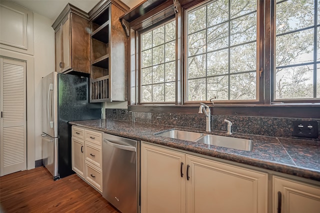 kitchen with cream cabinets, sink, appliances with stainless steel finishes, and dark hardwood / wood-style flooring