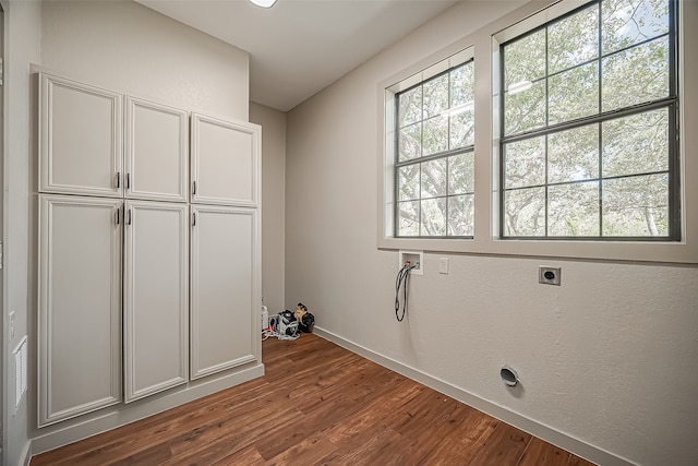 washroom with hookup for a washing machine, cabinets, hookup for an electric dryer, and hardwood / wood-style flooring