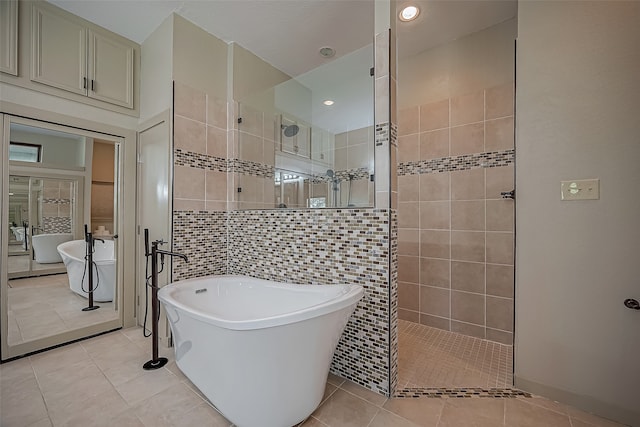 bathroom with tile walls, tile patterned flooring, and plus walk in shower