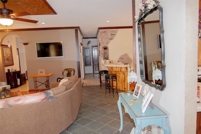 living room featuring crown molding, ceiling fan, tile patterned floors, recessed lighting, and arched walkways