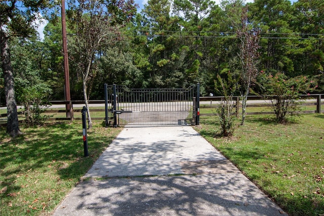 view of gate with fence and a yard