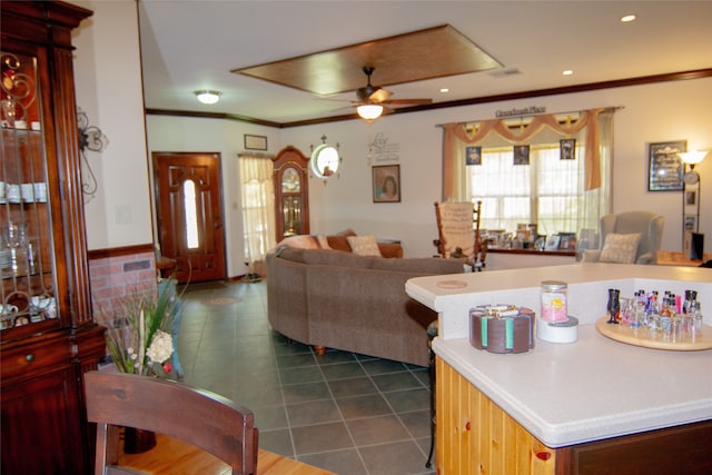 kitchen with crown molding, ceiling fan, and dark tile patterned flooring