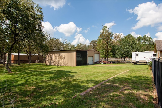 view of yard featuring an outdoor structure, a garage, and fence