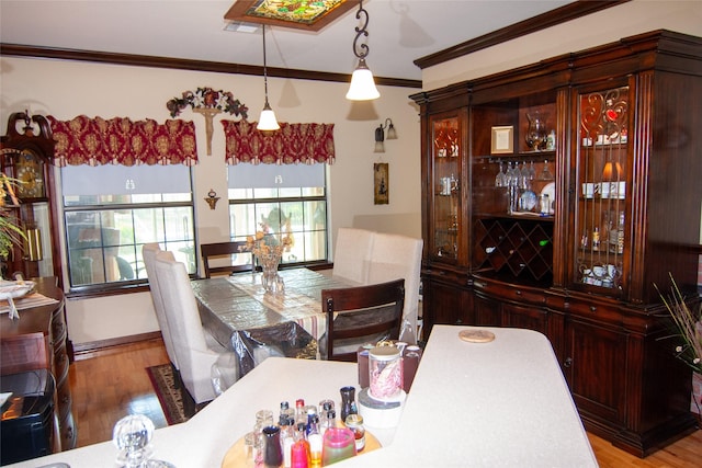 dining space with ornamental molding and wood finished floors