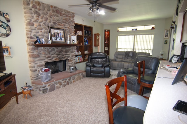 living room featuring ceiling fan, carpet floors, and a stone fireplace