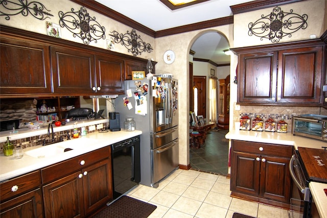 kitchen featuring decorative backsplash, crown molding, appliances with stainless steel finishes, arched walkways, and a sink