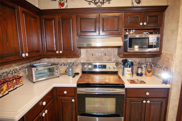 kitchen with backsplash, appliances with stainless steel finishes, and ventilation hood