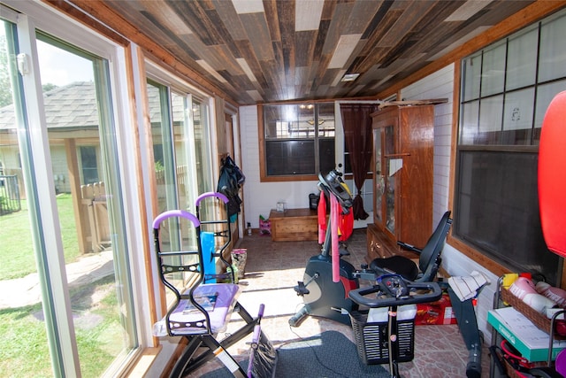 exercise area with wood walls and wood ceiling