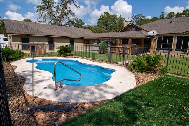 view of pool featuring a lawn, fence, and a fenced in pool