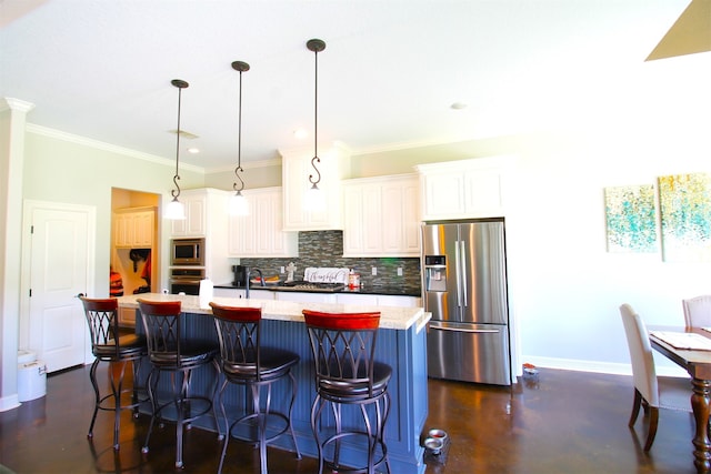 kitchen featuring appliances with stainless steel finishes, a center island with sink, white cabinetry, and pendant lighting